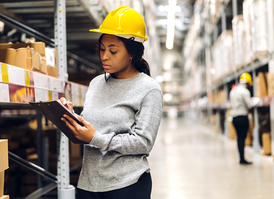 Business Insurance - Female Warehouse Worker Checking Inventory